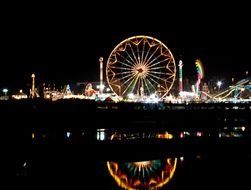 bright illuminated Ferris Wheel in amusement park at night