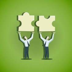 Two businessman trying to combine puzzle pieces