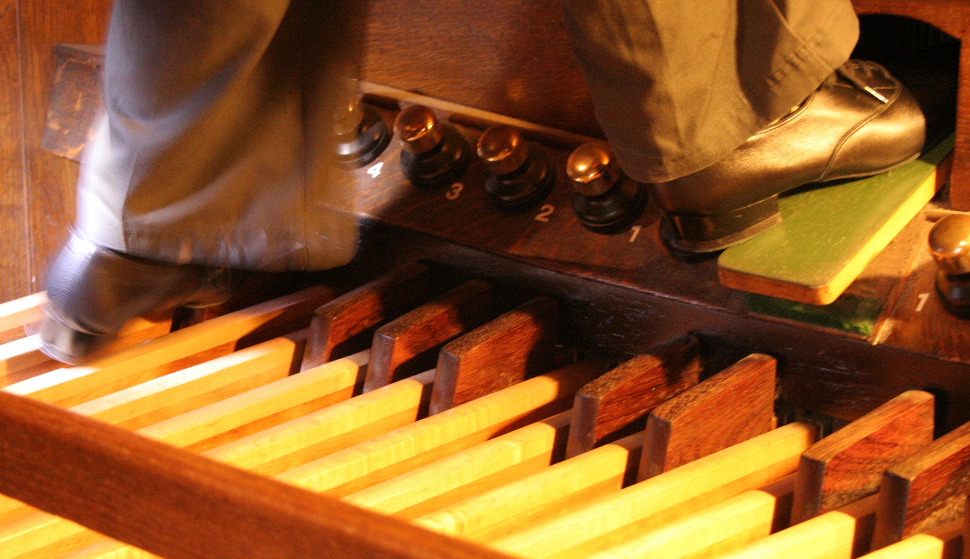 Feet on the pedals of a church organ free image download