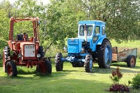 red and blue tractors on the lawn