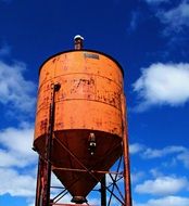 orange water tower against blue sky