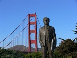 monument in front of golden gate bridge in san francisco and man statue