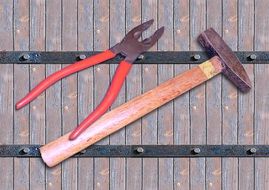 pliers and hammer on a wooden table