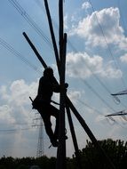 man climbing pillar beneath power line