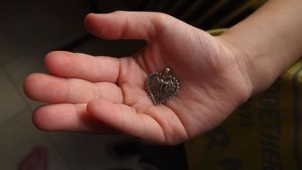 pendant in the shape of a heart in the hands of a child