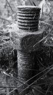 black and white image of a big screw in the grass