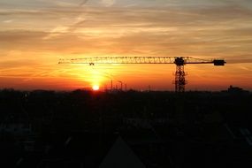 crane at an industrial plant against the backdrop of an orange sunset in Duisburg