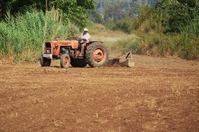 man on tractor cultivating field