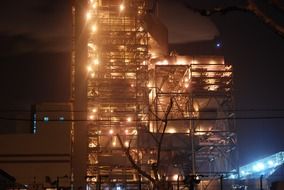 brightly lit factory building at night