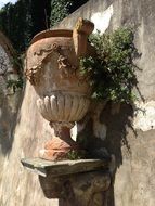 a vase on the facade of a building in Tuscany