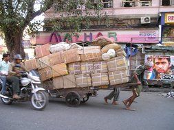 man carryng heavy load by street, hard work, india, mumbai