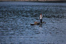 asian man on boat loaded with fruits