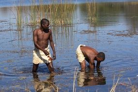 two african man in a pond in Namibia