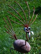 A bird made of stones and wire among the park