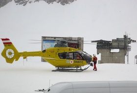 emergency helicopter on snow in mountains