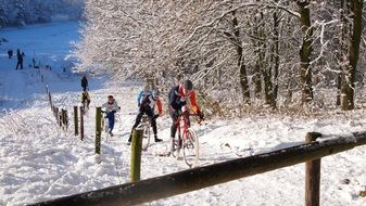 cyclists ride the mountain in the snow