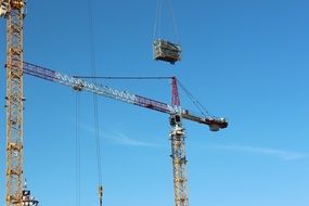two construction cranes on site