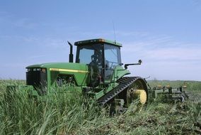 green tractor among tall grass