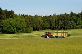 Tractor with a trailer on the field