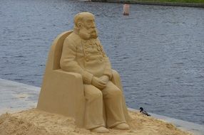 sand statue of a man in an armchair