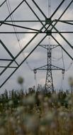 transmission towers with power lines at cloudy sky