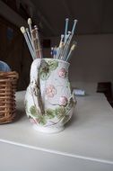 knitting needles in a jug on the table