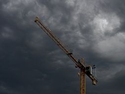 construction crane under dark clouds