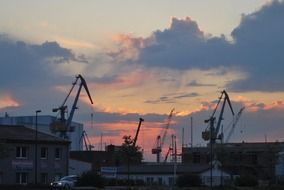 cranes in port at evening sky