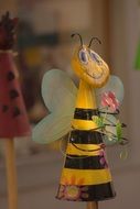 bee holds flower, metal garden figure