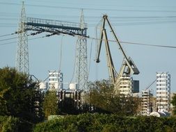 industrial cranes among power lines