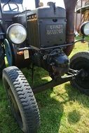 front of an old tractor on green grass