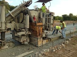 workers work on heavy equipment
