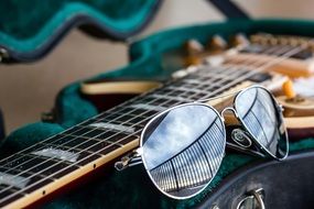 sunglasses lie on the guitar
