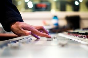 human hands on mixing console