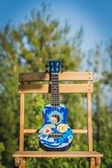 blue guitar hanging on a wooden stand