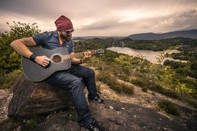 guitarist sitting on the stone
