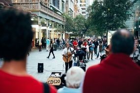 street musician playing guitar and selling compact disks