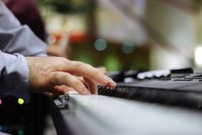 fingers of a musician on a piano keyboard