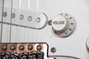 grey electric guitar with volume control