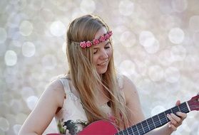 girl is playing a pink guitar