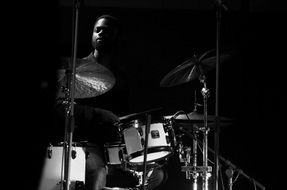 musician behind a drum kit in the dark