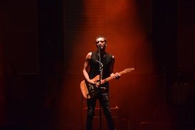 singer with guitar on stage