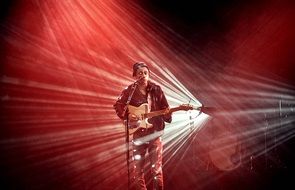 musician with guitar in red lights