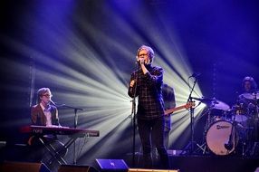 singer at a concert on the background of a light show