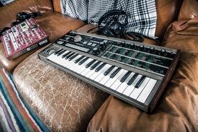 synthesizer micro KORG on a sofa