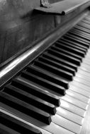 Side view of black and white piano keys in black and white background