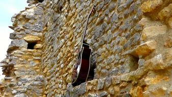 acoustic guitar at aged stone wall