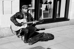 man playing guitar on street