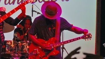 bass guitar player in a hat at a concert