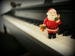 closeup picture of santa claus figurine on piano keys